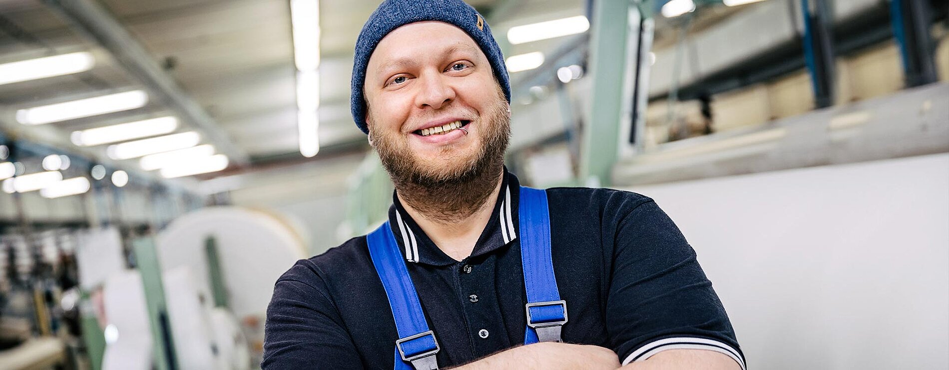 Mitarbeiter in der Velener Textilproduktion vor einer Spinnmaschine