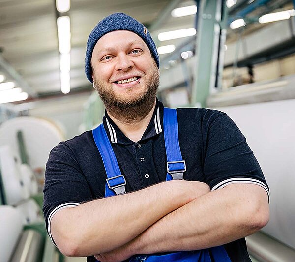Mitarbeiter in Arbeitskleidung vor Textilmaschinen in der Produktion von Velener